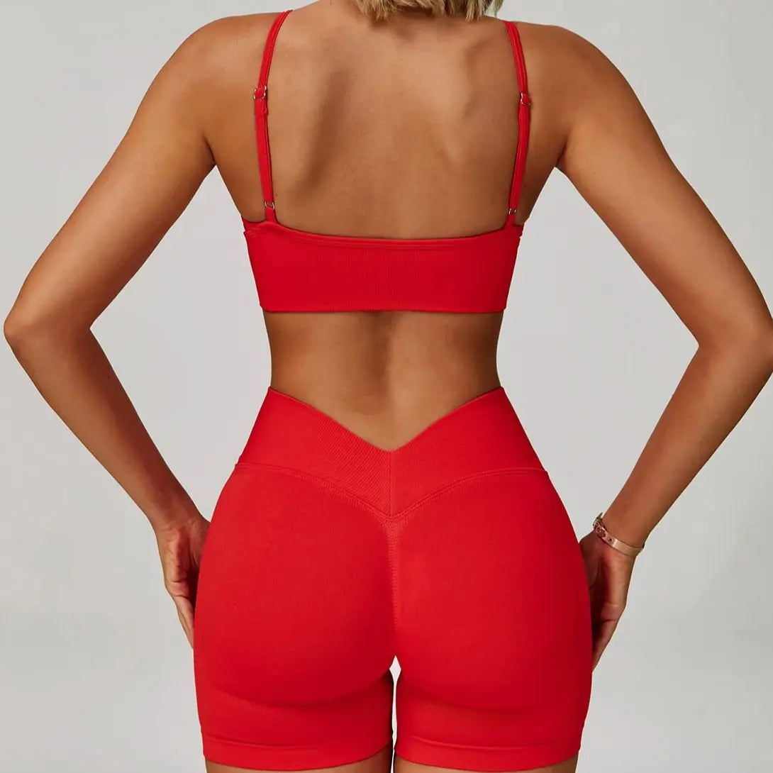 Eine Frau modelliert ein rotes, nahtloses Sport-Yoga-Set mit Crop-Top und hochtaillierten Leggings.