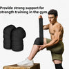 A muscular man demonstrates the use of black knee wraps for strength training in a gym setting.