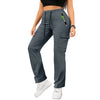 A woman wearing dark gray drawstring cargo pants and a black top, standing and looking down.