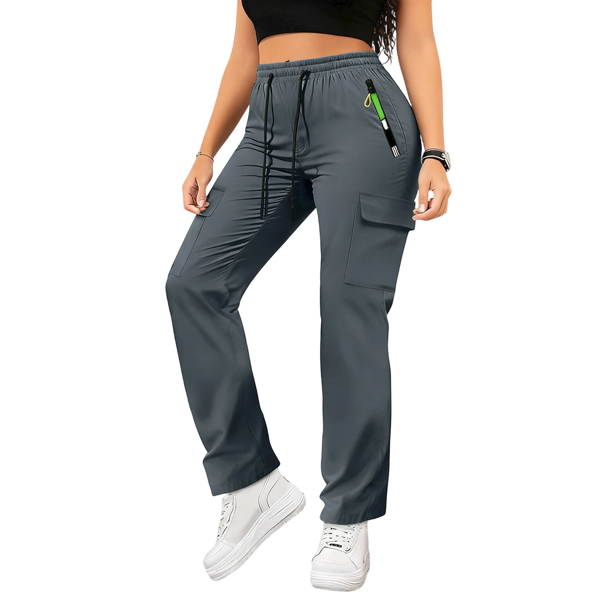 A woman wearing dark gray drawstring cargo pants and a black top, standing and looking down.