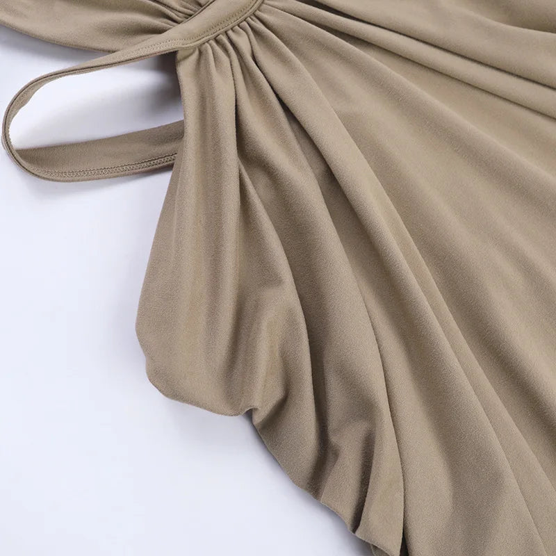 A beige maxi dress with a draped cut-out back, shown in a soft fabric.