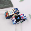 A close-up of a stretch silicone wristband bracelet featuring a blue and white floral pattern with a small patch.
