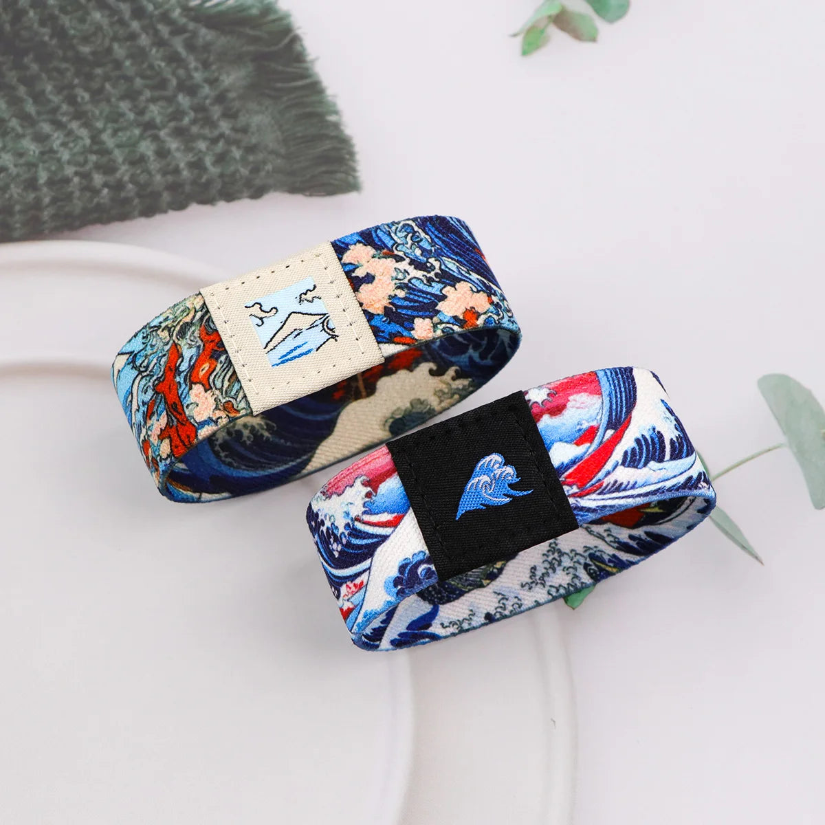 A close-up of a stretch silicone wristband bracelet featuring a blue and white floral pattern with a small patch.