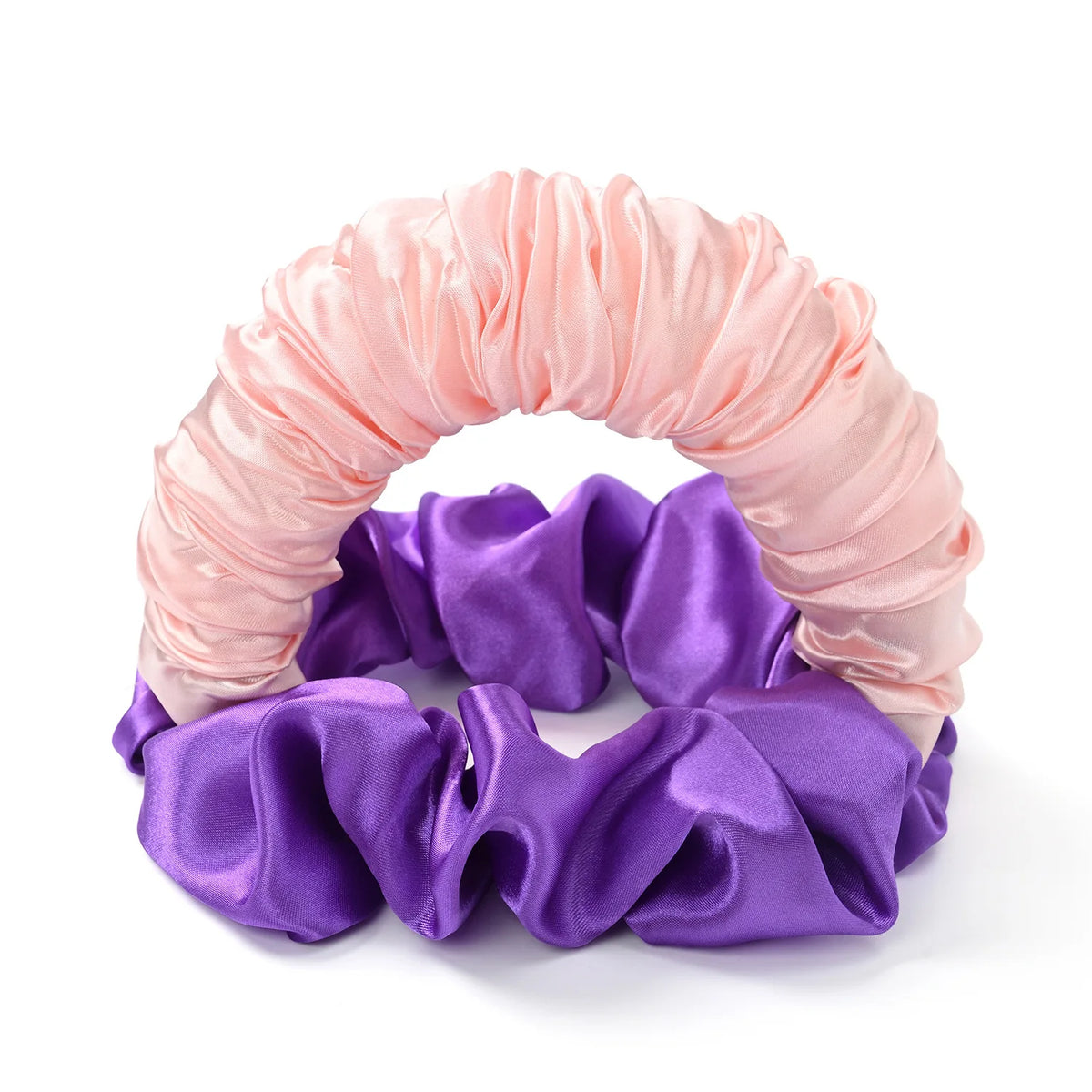 A headband made of silky fabric in shades of pink and purple for heatless curling.