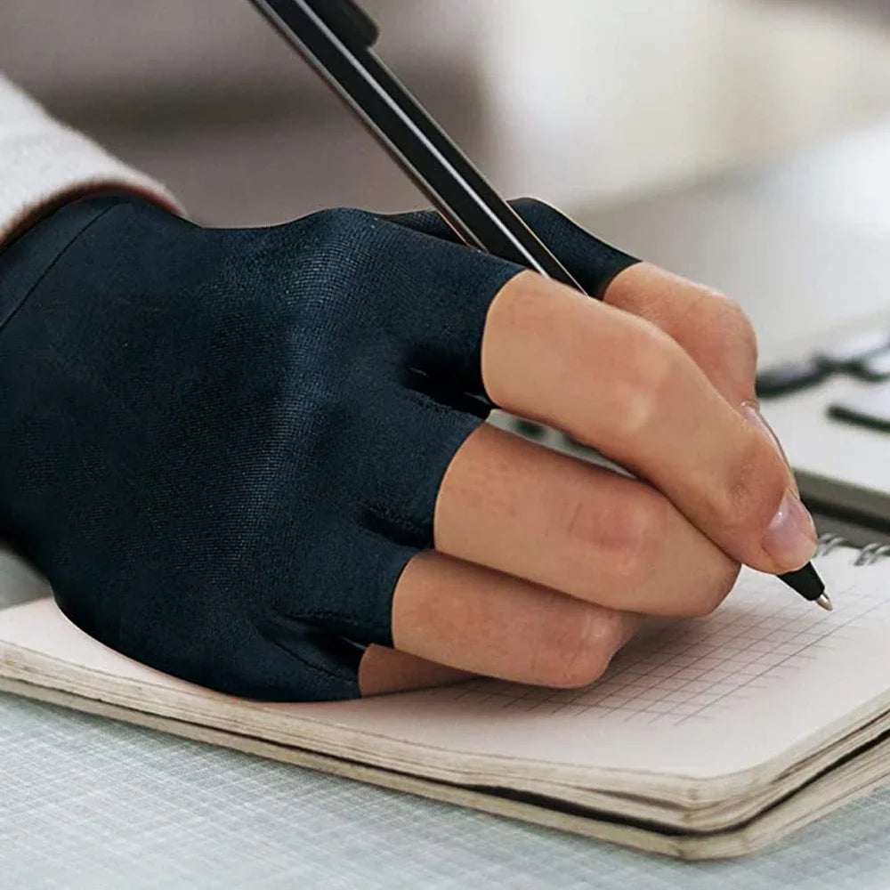 A hand wearing a black compression fingerless glove is writing in a notebook.