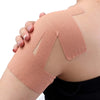 A hand is applying a beige elastic patch for shoulder pain relief onto a person's shoulder.