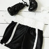 Colgantes de guantes de boxeo de cuero negro y shorts deportivos blanco y negro