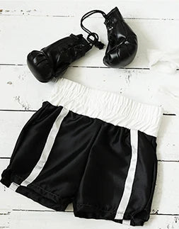 Colgantes de guantes de boxeo de cuero negro y shorts deportivos blanco y negro