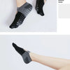 A pair of black and gray half toe design yoga socks worn on a foot.