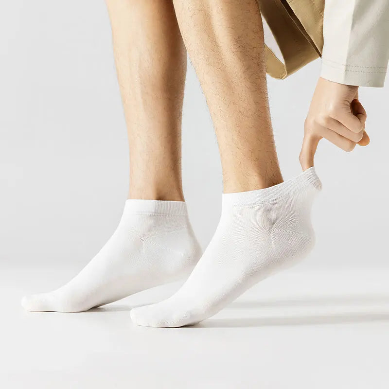 A close-up shot of a person's leg wearing white men's combed cotton socks.