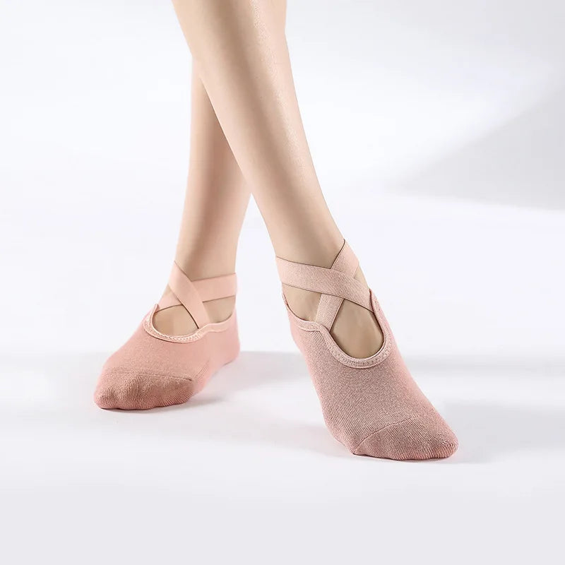 A pair of nude pink breathable silicone yoga and pilates socks worn on a person's feet.