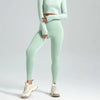 A model wearing light mint green seamless high-waist yoga leggings and a matching long-sleeved top.