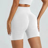 Un mannequin porte des shorts de yoga sans couture taille haute blancs pour la salle de sport et la fitness.
