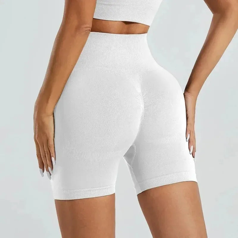 Un mannequin porte des shorts de yoga sans couture taille haute blancs pour la salle de sport et la fitness.