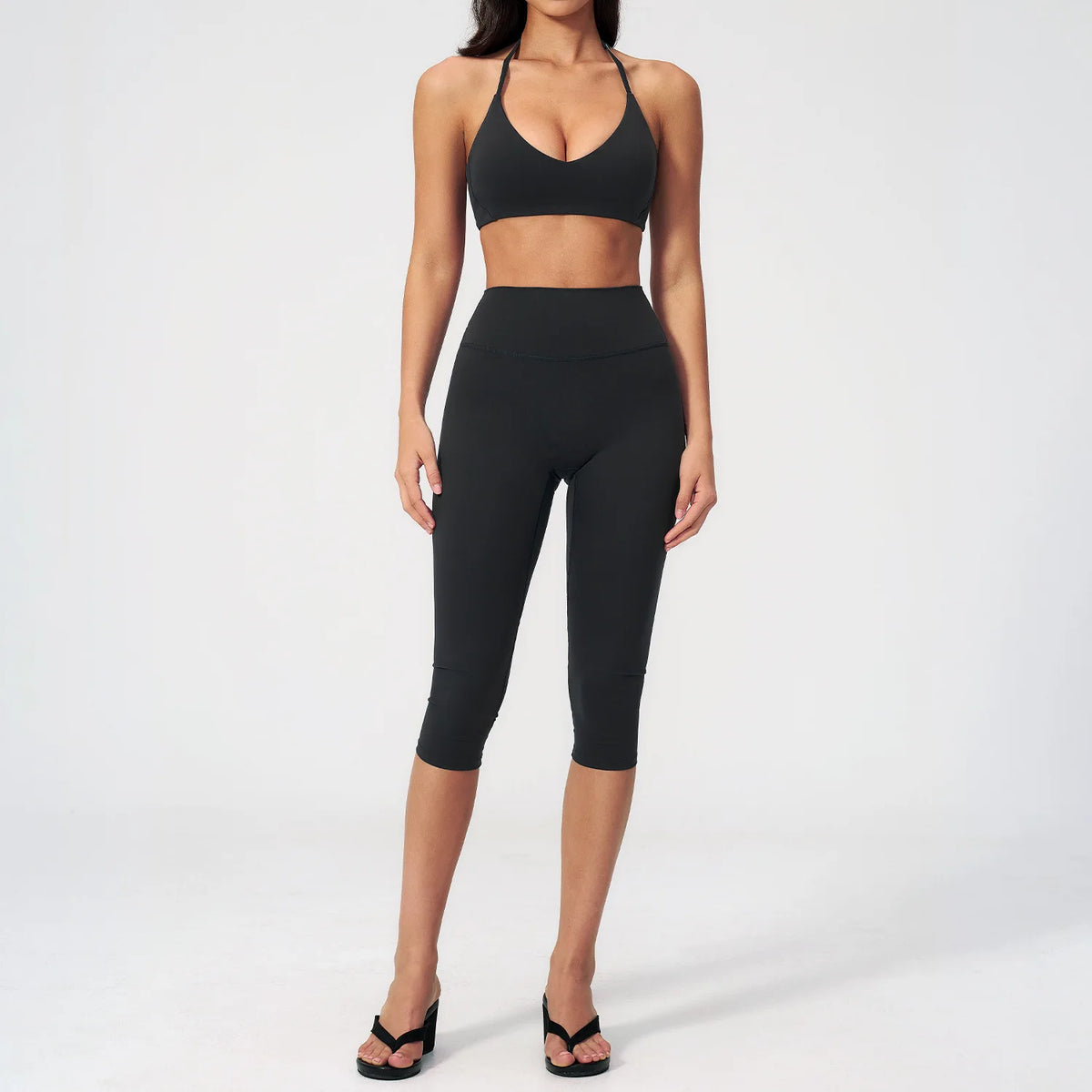 A woman wearing a black women's premium fitness tracksuit top and leggings.