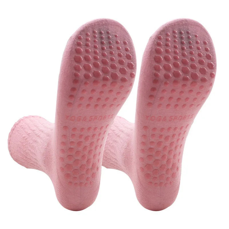 A pair of pink silicone Pilates and yoga socks with textured soles.