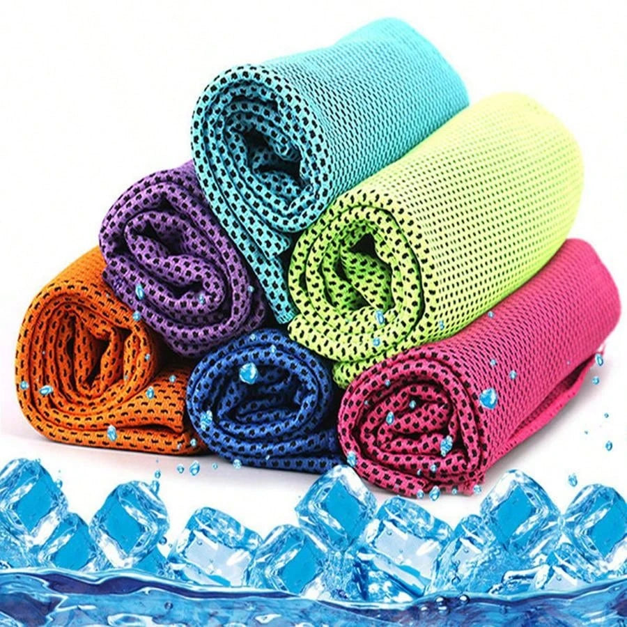 Une pile de serviettes microfibres colorées roulées, avec des glaçons au premier plan.