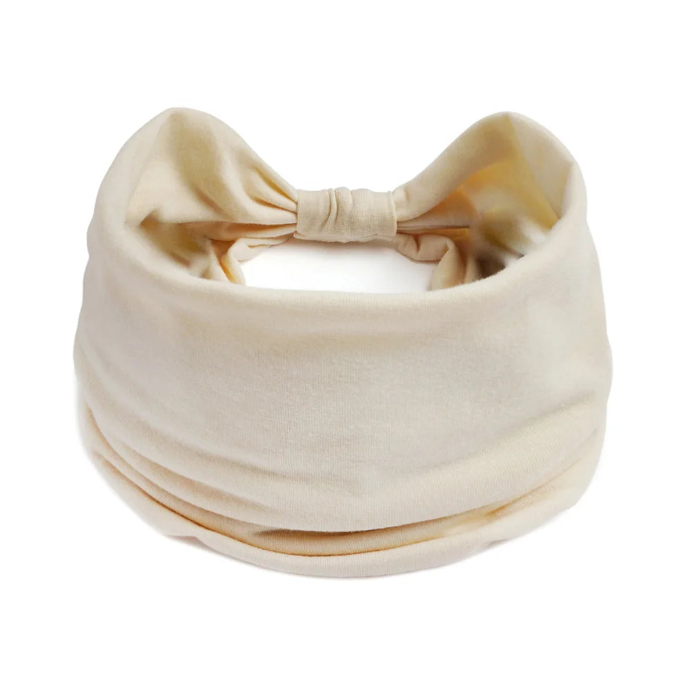 Un foulard en coton bohème beige noué en nœud, montré à plat.