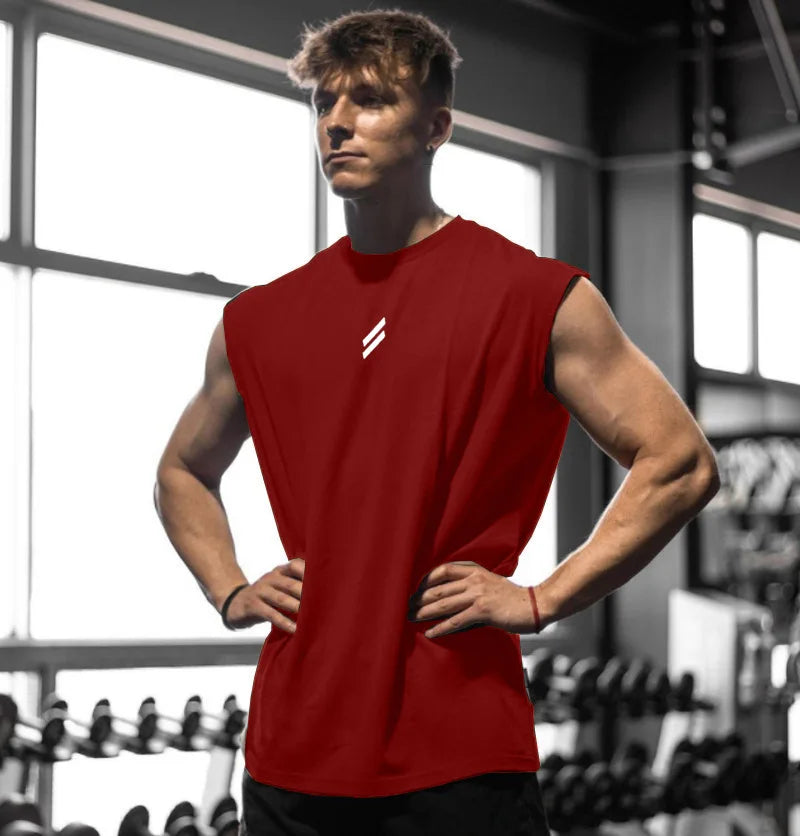 Männliches Modell trägt ein rotes, schnelltrocknendes ärmelloses Fitness-Tanktop im Fitnessstudio.