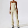 A woman wearing a beige women's performance tracksuit set, including a tank top and matching pants.