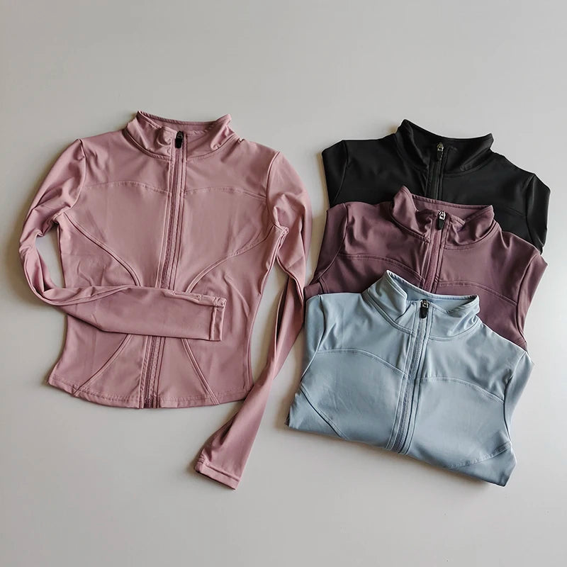 Three pink, black, and light blue quick-dry yoga and fitness jackets laid out on a white surface.