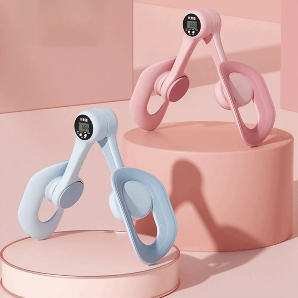 A pair of pink and light blue thigh and hip strength trainers are displayed on a pink pedestal.