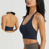 A woman wearing a navy blue halter neck sports bra top for yoga or gym activities.
