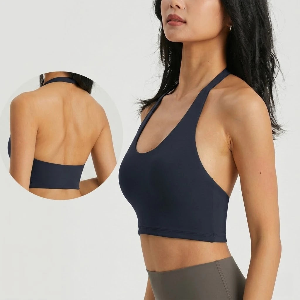 A woman wearing a navy blue halter neck sports bra top for yoga or gym activities.