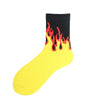A yellow sock with a black top featuring a bright orange and red flame pattern.