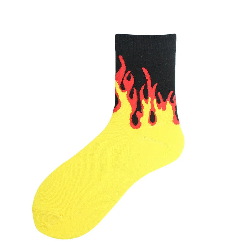 A yellow sock with a black top featuring a bright orange and red flame pattern.