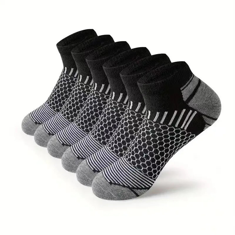 A stack of black and gray athletic knit ankle socks for men displayed on a white background.