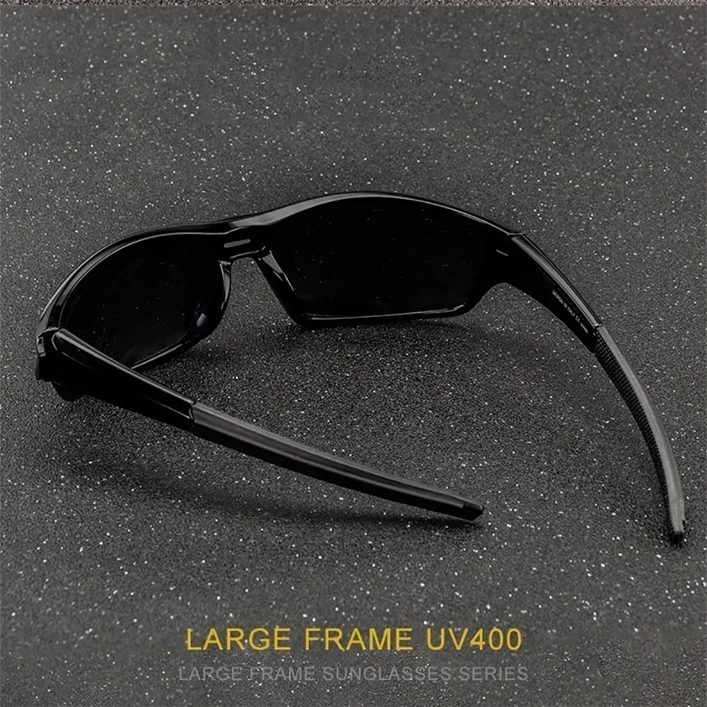 Une paire de lunettes à monture noire et grande est présentée sur un fond sombre et tacheté.