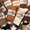 A collection of thick cotton tube socks in various earthy tones including brown, beige, and gray.