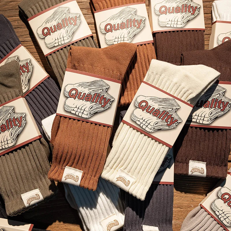 A collection of thick cotton tube socks in various earthy tones including brown, beige, and gray.