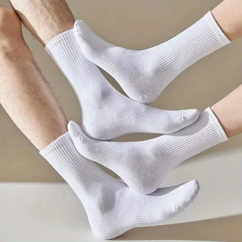 Une paire de chaussettes pour hommes en coton mélangé blanches portées sur les pieds d'une personne.