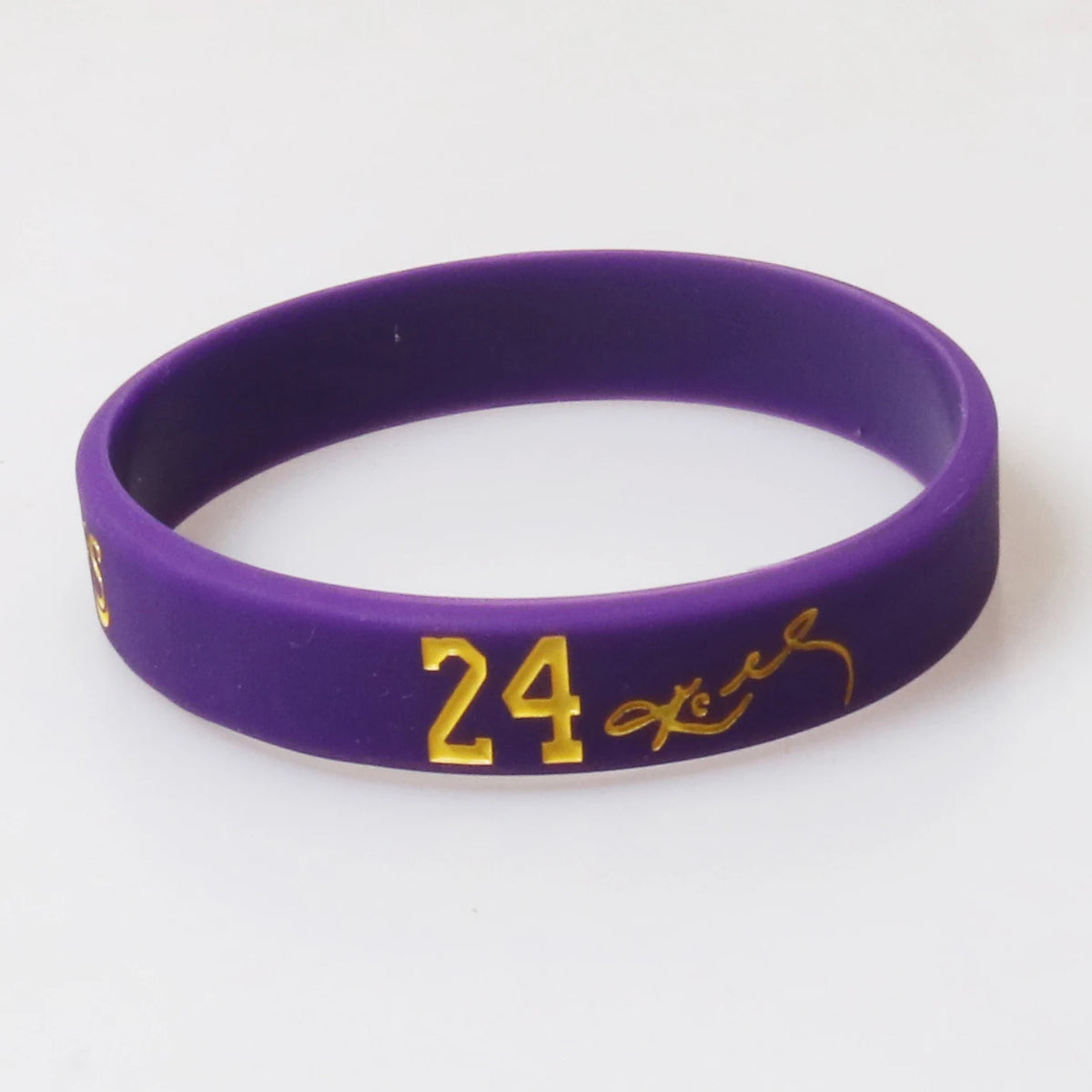 A purple silicone wristband with the number 24 and a signature engraved on it.