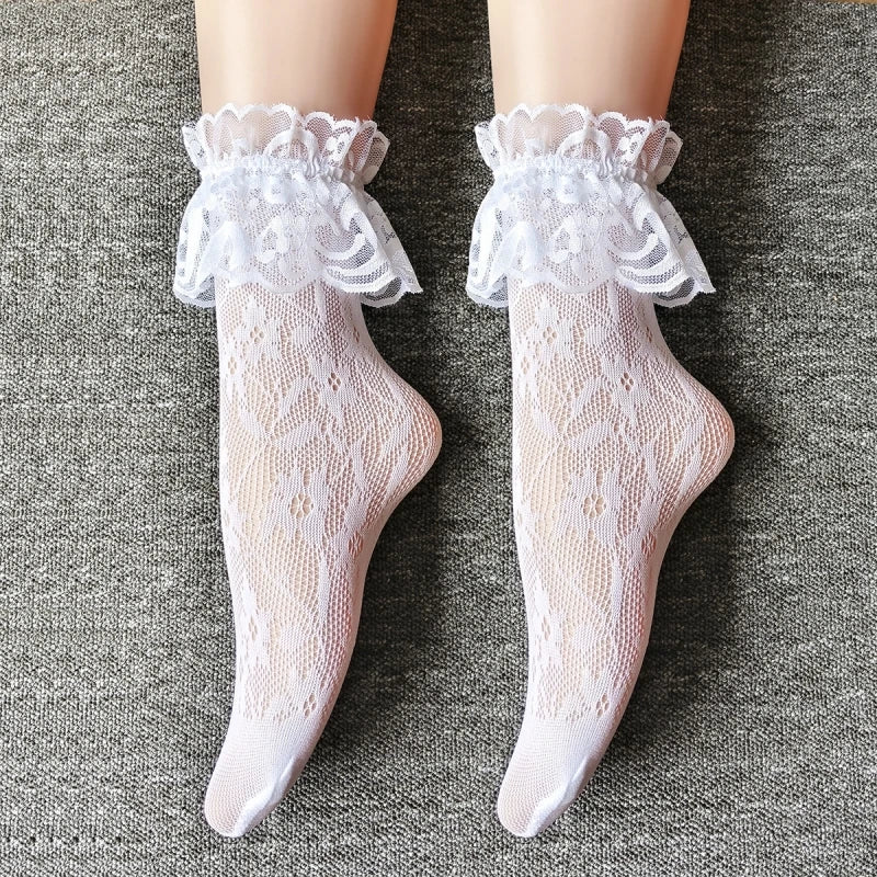 Paar durchsichtige weiße Spitzenstrumpfhosen mit Rüschen und Blumenmuster