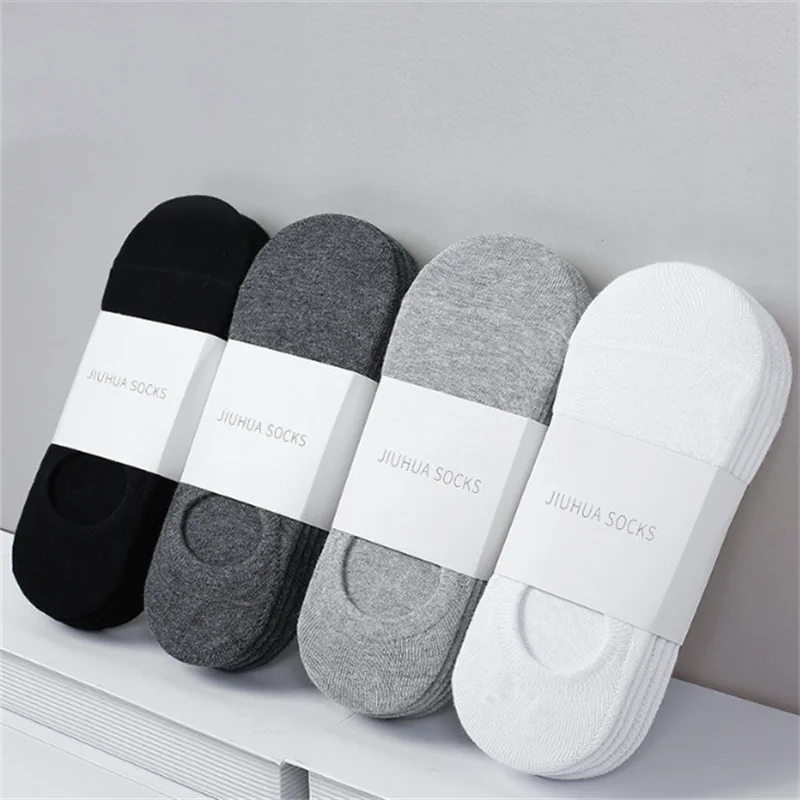 A row of various colored JiuHua socks, including black, gray, and white, displayed on a white surface.
