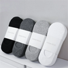 A row of JiuHua socks in black, gray, and white are displayed on a white surface.