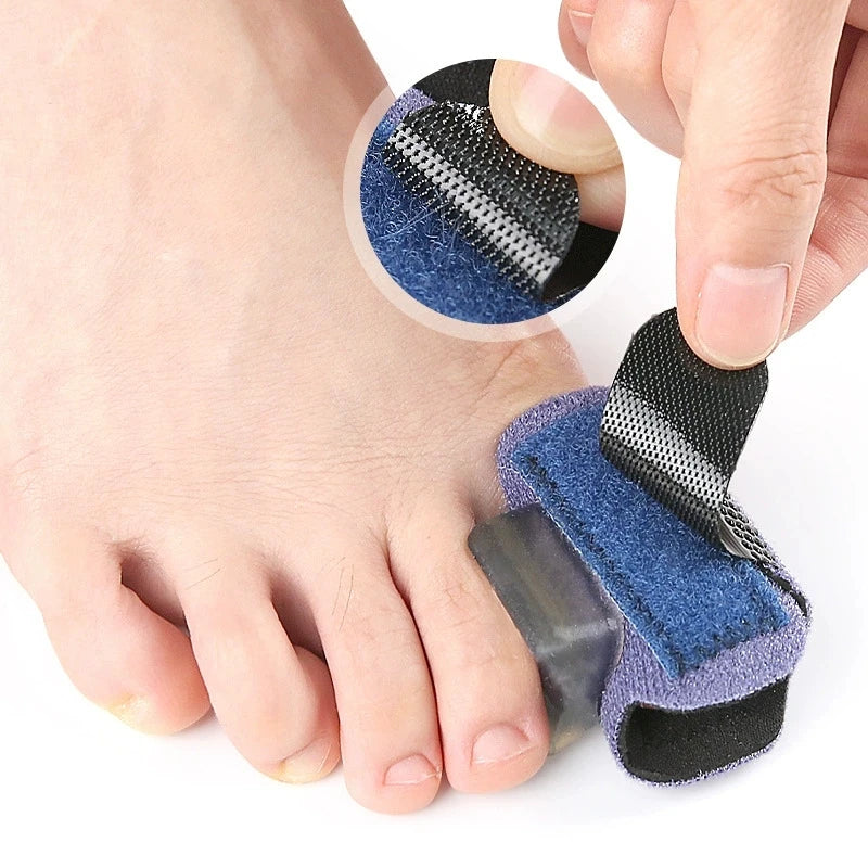 A hand is adjusting a blue and black adjustable toe splint designed for hammer toes or crooked fingers.
