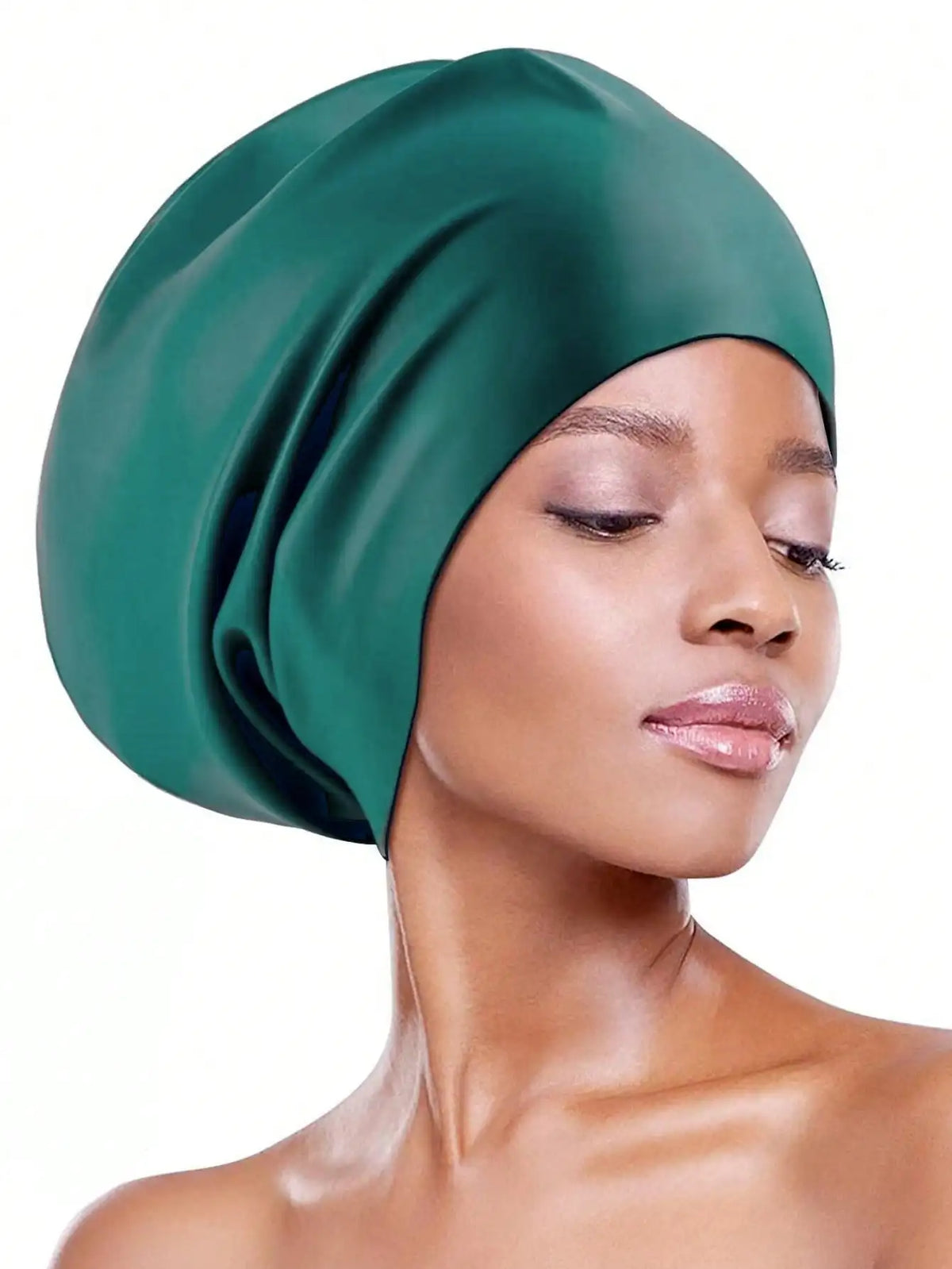 A close-up of a woman wearing a deep emerald green silicone swim cap for long hair.