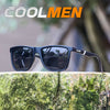 A pair of black polarized sports sunglasses resting on a mossy tree branch in an outdoor setting.