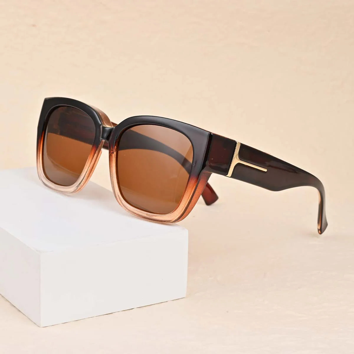 Brown tortoiseshell sunglasses resting on a white box.