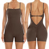 A woman models a brown, backless fitness jumpsuit from the rear view.