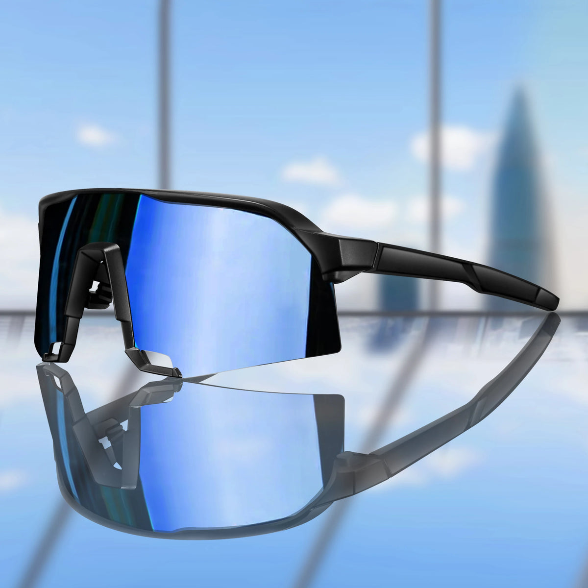 A pair of black polarized cycling sunglasses resting on a reflective surface.