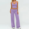 A woman wearing a purple women's premium fitness tracksuit top and matching pants.