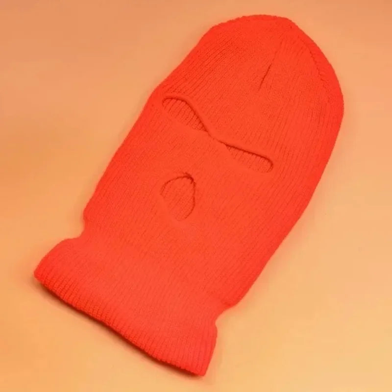 A bright orange knit balaclava beanie hat shown from the front.