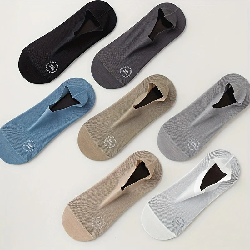 Un paquete de cuatro calcetines de verano transpirables en varios tonos de gris y azul, dispuestos sobre una superficie blanc