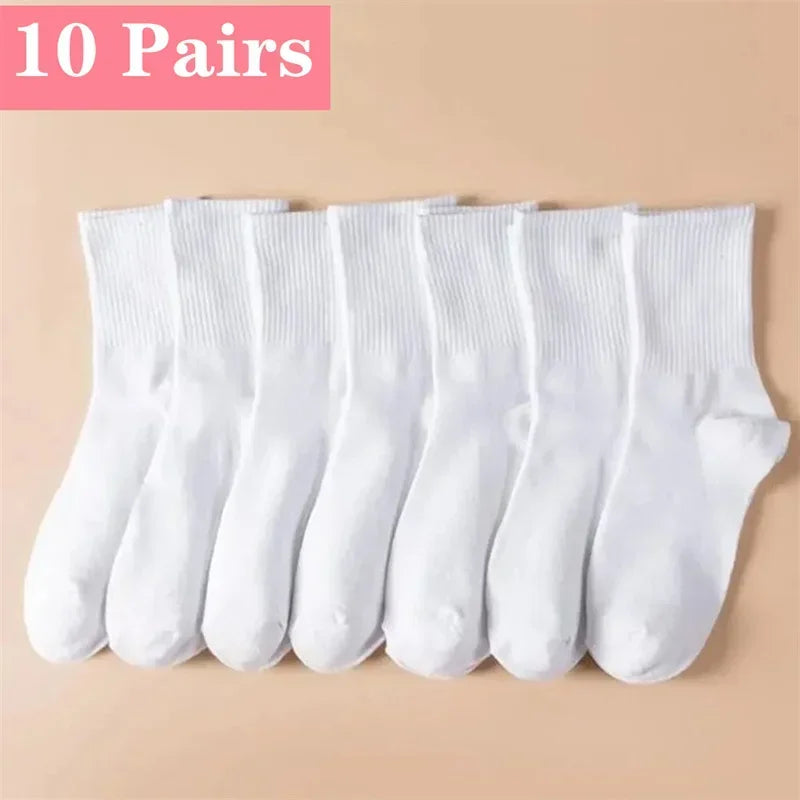 Dix paires de chaussettes en tricot blanches et respirantes disposées en rangée.