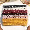 Eine Sammlung von Stoff-Polka-Dot-Haarbändeln in verschiedenen Farben darunter Schwarz, Weiß, Weinrot, Braun, Pink und Gelb.